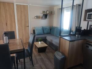 ein kleines Wohnzimmer mit einem Sofa und einem Tisch in der Unterkunft Mobil home Le Galland de Dugny in Onzain