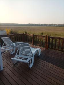 two lounge chairs on a deck with a view of a field at Mobil home Le Galland de Dugny in Onzain
