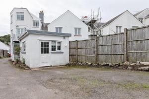 een wit huis met een hek ervoor bij 2 bedroom flat in The Mumbles with free parking in The Mumbles