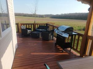 einen Grill auf einer Terrasse in einem Haus in der Unterkunft Mobil home Le Galland de Dugny in Onzain