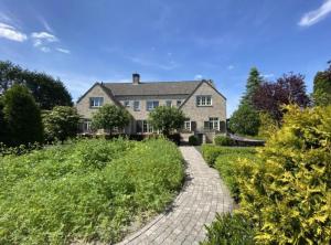 a large house with a brick walkway leading to it at Sfeervol familielandhuis in de groene Kempen in Baarle-Hertog