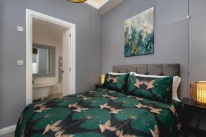 a bedroom with a bed with a green comforter at Marine Parade Sea View 2-Bedroom Apartment in Brighton & Hove