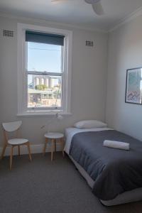 a bedroom with a bed and a window and a chair at Seven Seas Hotel in Carrington