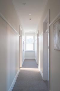 a hallway with white walls and a window at Seven Seas Hotel in Carrington