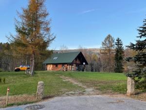 Cabaña de madera con techo verde en un campo en Berghütte - Chalet für 4-6 Personen - Schwarzenberg am Böhmerwald, en Schwarzenberg am Bohmerwald