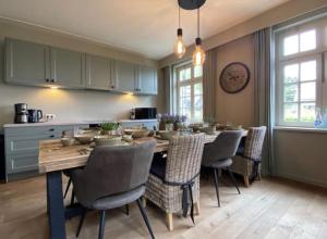 a kitchen with a dining room table and chairs at Sfeervol landhuis in de groene Kempen in Baarle-Hertog