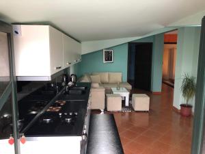 a kitchen with a stove and a couch in a room at Villa Ceni in Elbasan