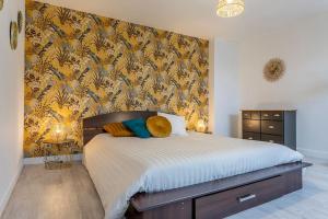 a bedroom with a large bed with yellow and blue wallpaper at L' appartement de la Paix in Romorantin