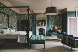 um quarto com uma cama, uma lareira e um espelho em Hampton Manor em Hampton in Arden