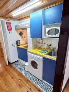 a small kitchen with a washing machine and a sink at Casa em Alfama in Lisbon