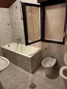 a bathroom with a tub and a toilet and a sink at Rooms Juran in Sukošan