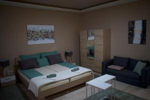 una camera con un letto e un divano blu di Gerti Apartman 2 a Nyíregyháza