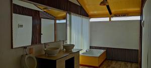 een badkamer met 2 wastafels, een toilet en een bad bij Los Uros Lago Titicaca in Puno