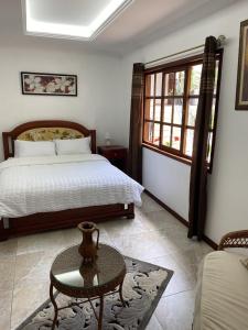 a bedroom with a bed and a table in it at El Castillo de Nallig in Gualaceo