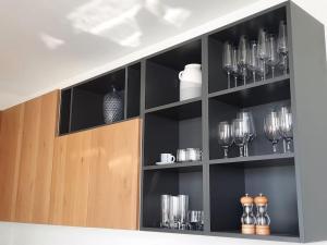 a shelf with glasses and vases on it at Cloud 7 Quality Sea Front Apartment in Marsaskala