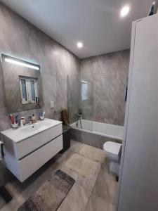 a bathroom with a sink and a toilet and a tub at Cloud 7 Quality Sea Front Apartment in Marsaskala
