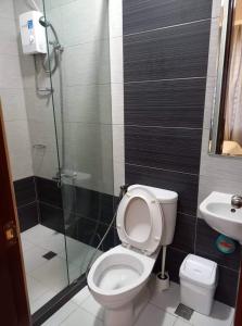 uma casa de banho com um chuveiro, um WC e um lavatório. em GLC SUITES em Bislig