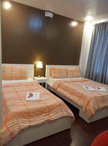 duas camas num quarto de hotel com em GLC SUITES em Bislig