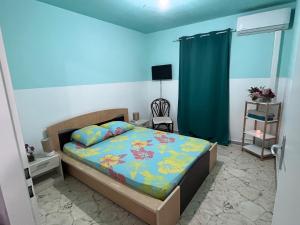 1 dormitorio con 1 cama con pared azul en Chambre d'hôte à 5Mn de l’aéroport en Les Abymes