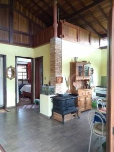 a living room with a stove and a bedroom at Sitio Boa Fé - 300m das cachoeiras Moinho e Salomão in Carrancas