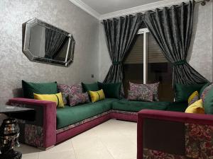 a living room with a green couch and a mirror at Appartement Tanger in Tangier