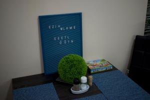 stół z zieloną rośliną i znakiem na ścianie w obiekcie Gerti Apartman w Nyíregyházie