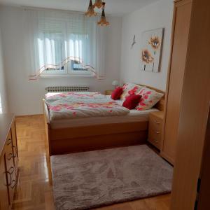 a small bedroom with a bed and a window at Apartment Meli Varazdin in Varaždin