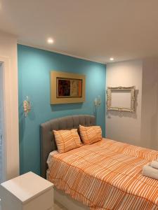 Schlafzimmer mit einem Bett mit blauer Wand in der Unterkunft Fernando Lemos Estúdio Lisboa in Lissabon