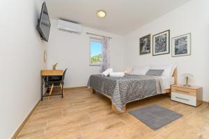 sypialnia z łóżkiem, biurkiem i oknem w obiekcie Rooms FOREVER w mieście Miholašćica