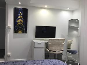 a bedroom with a desk with a television and a chair at Studio côté Parc des Contades in Strasbourg