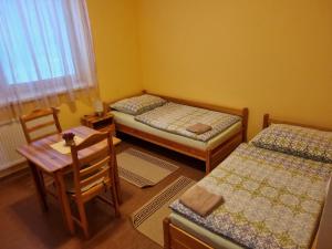 um quarto com duas camas e uma mesa e cadeiras em Penzión Oponice em Oponice