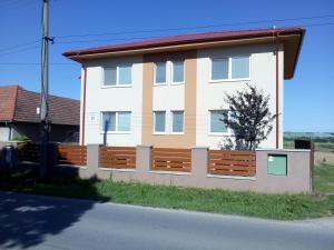 a house with a wooden fence in front of it at Penzión Oponice in Oponice