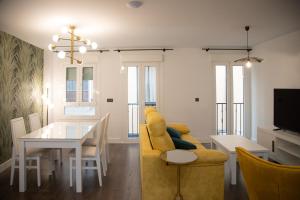 a living room with a yellow couch and a table at Apartamentos Boutique Cervantes in Plasencia
