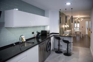 a kitchen with a sink and a washing machine at Apartamentos Boutique Cervantes in Plasencia