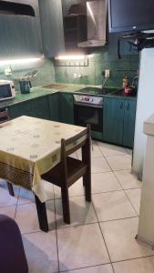 a kitchen with green cabinets and a table with a chair at Apartment on Privokzalnaya 2/1 in Vinnytsya