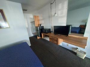 a living room with a tv and a desk with a tvictericterictericter at Royal Inn Casper in Casper