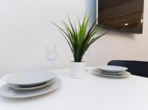 einem Tisch mit Platten und einer Topfpflanze darauf in der Unterkunft Bayswater Apartments with Free Parking in Leeds