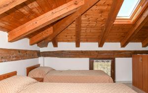 two beds in a room with wooden ceilings at Stars Apartments Gressan in Cerise