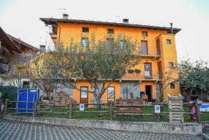 an orange building with a tree in front of it at Stars Apartments Gressan in Cerise