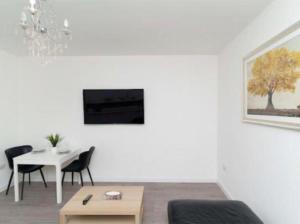ein weißes Wohnzimmer mit einem Tisch, einem Tisch und Stühlen in der Unterkunft Bayswater Apartments with Free Parking in Leeds