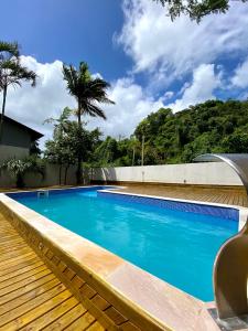 une grande piscine bleue à côté d'une maison dans l'établissement Pousada Altas Natureza, à Florianópolis