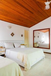 a bedroom with two beds and a large mirror at Pousada Brilho da Serra in Tiradentes