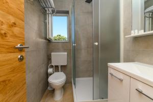 bagno con servizi igienici, lavandino e finestra di Rooms FOREVER a Miholašćica
