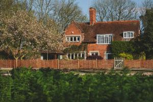ein Backsteinhaus mit einem Zaun davor in der Unterkunft Hampton Manor in Hampton in Arden