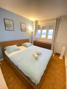 ein Schlafzimmer mit einem großen Bett mit zwei Handtüchern darauf in der Unterkunft Superbe appartement proche de Paris in Colombes
