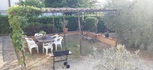 un giardino con tavolo, sedie e altalena di Casa MARIA , Appartamento nel cuore della Toscana a Larciano