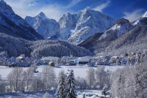 una ciudad en la nieve con montañas en el fondo en The Green House, en Mojstrana