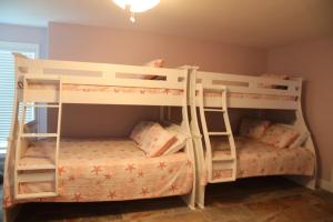 two bunk beds in a childs bedroom at Executive Keys Condominiums on the Beach in Port Aransas