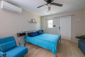 a bedroom with a bed and a couch and a ceiling fan at TheCozyCorner in Concord in Concord
