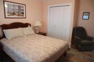 um quarto com uma cama e uma cadeira em Executive Keys Condominiums on the Beach em Port Aransas